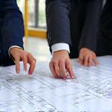 Project management discussion with blueprints onsite